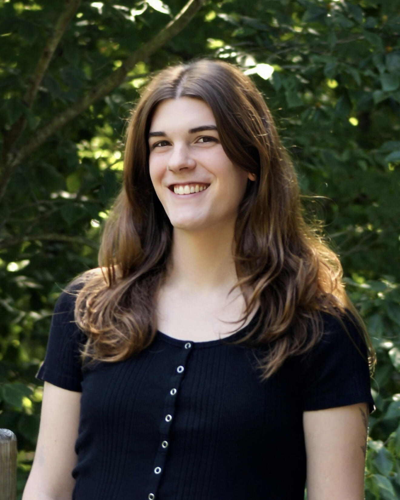 Photo of Nora Mahon, a young, white woman with brown hair, wearing a black shirt.
