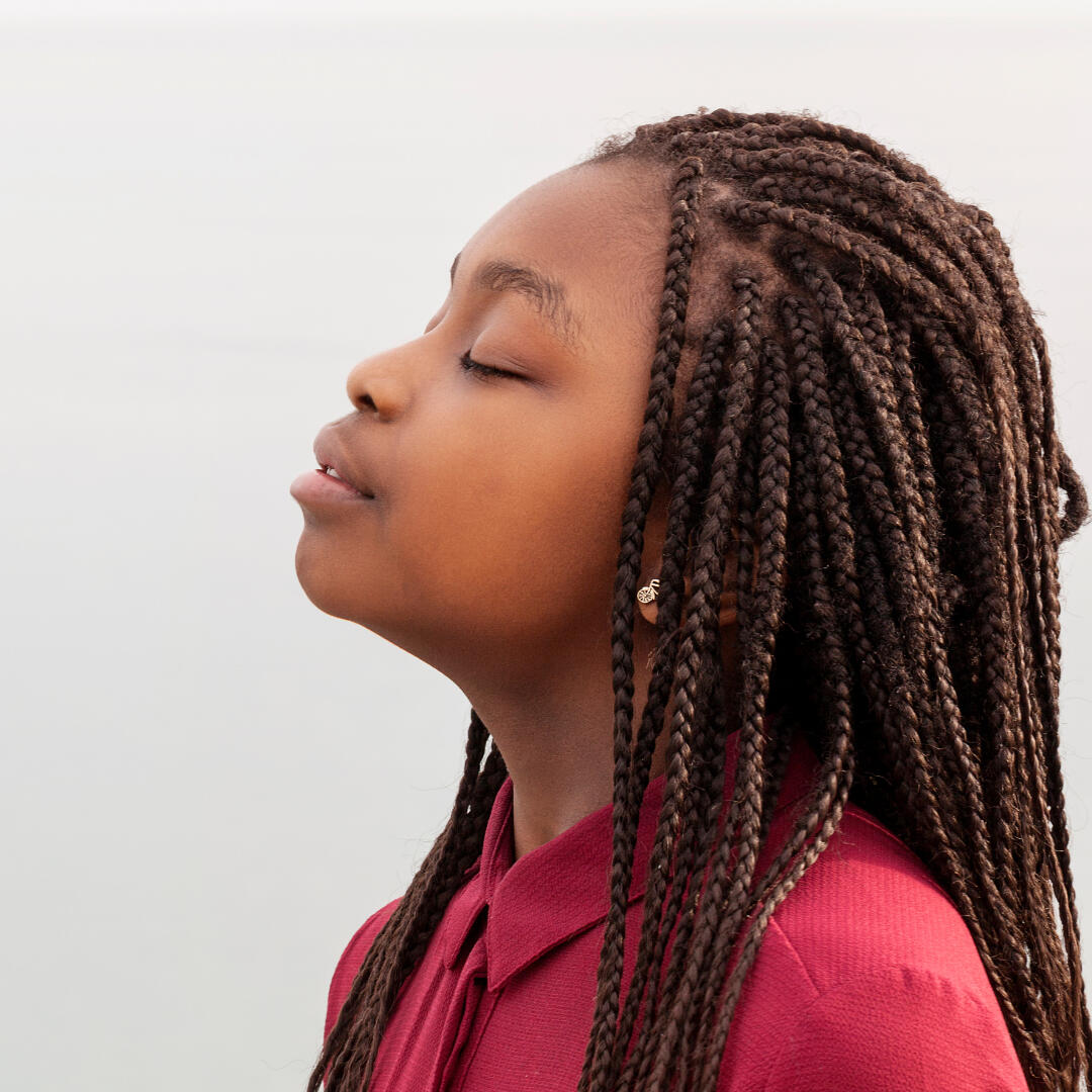 A photo of a woman from the side, with her chin elevated.